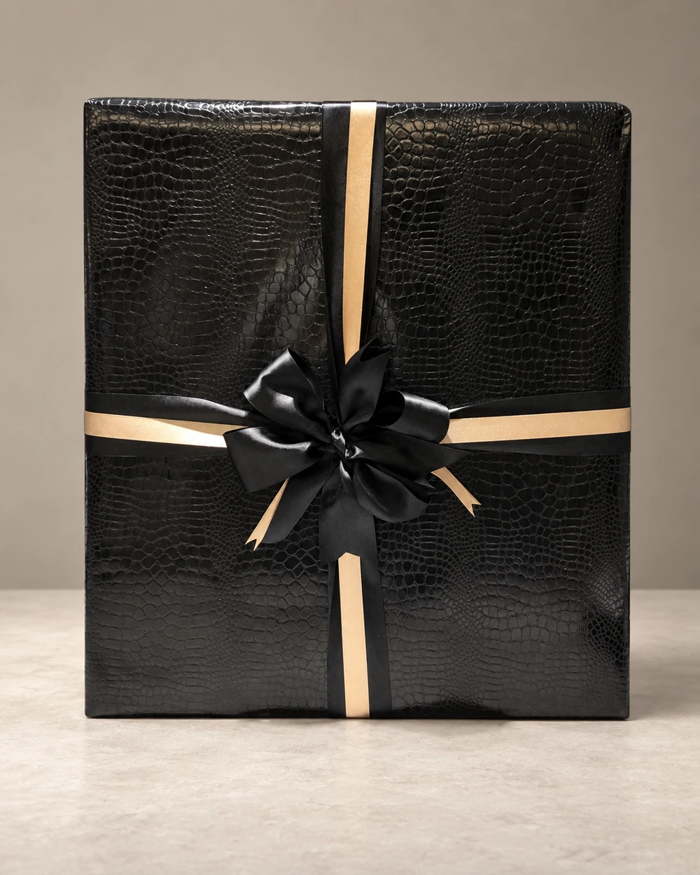 Black textured gift wrapping with black satin and gold ribbon